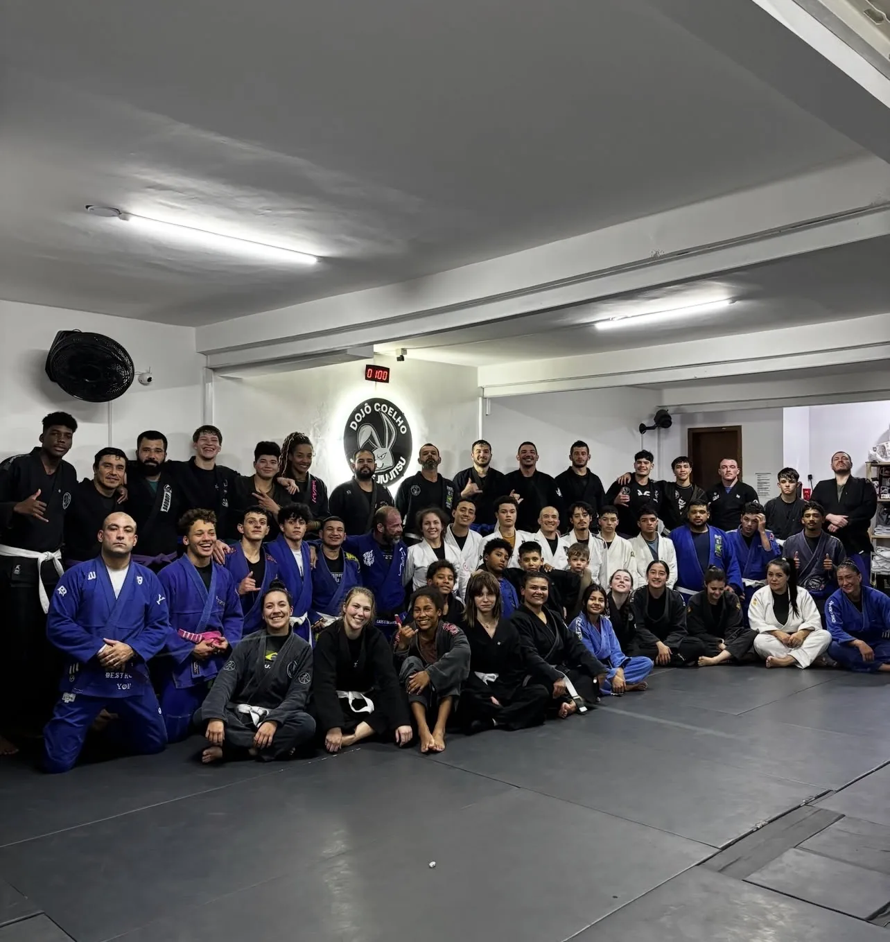 Turma de adultos e adolescentes reunida no tatame do Coelho Dojô